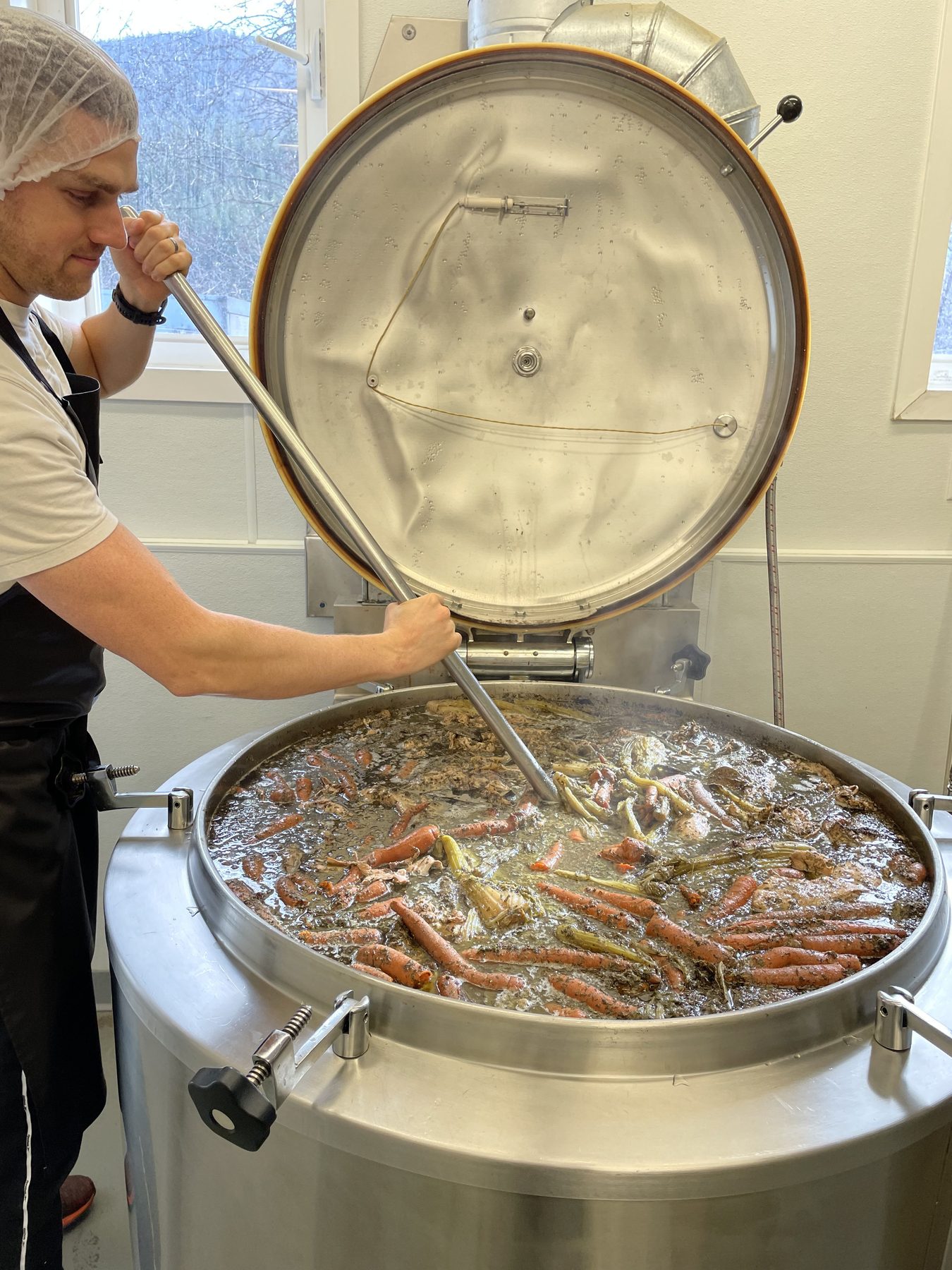 Sean stirring a large kettle of Wild Moon bone broth
